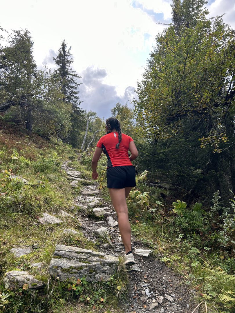 Dame går på sti i skog